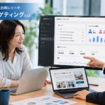 指定URLターゲティングについて、Web広告の配信データやURLリストを確認しながら、見込み客への広告配信方法を打ち合わせしているビジネス写真風イメージ